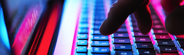 Close-up of person typing on laptop keyboard.